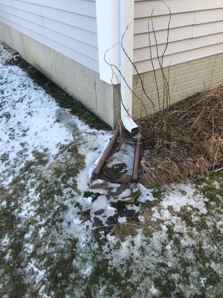 Downspout discharging water above the ground